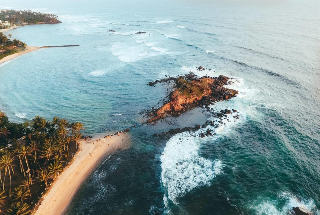 A pristine tropical beach in Sri Lanka with palm trees and calm ocean waves